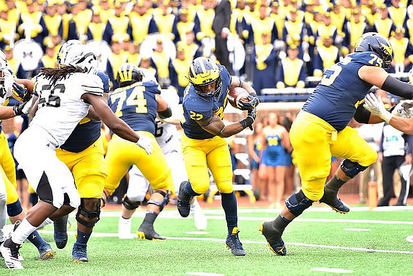 Ben Bredeson (74), Karan Higdon (22), and Jon Runyan Jr. (75)