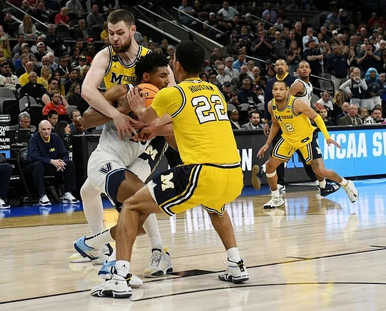 Caleb Houstan (22), Hunter Dickinson (1), DeVante' Jones (12), and Juwan Howard