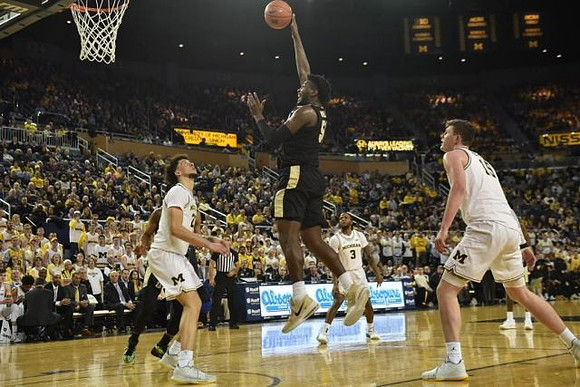 Brandon Johns Jr. (23), Zavier Simpson (3), and Jon Teske (15)
