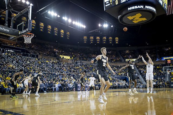 Franz Wagner (21), Zavier Simpson (3), and Jon Teske (15)