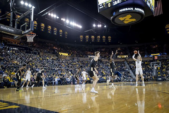 Franz Wagner (21), Zavier Simpson (3), and Jon Teske (15)