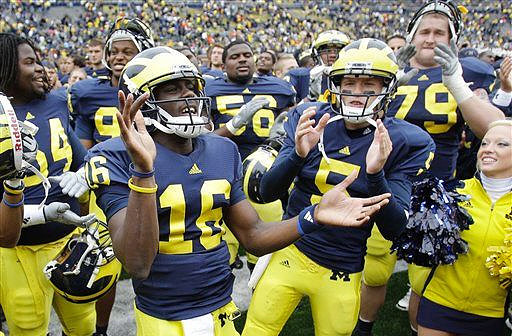 Denard Robinson (16), Tate Forcier (5), Ricky Barnum (56), and Perry Dorrestein (79)