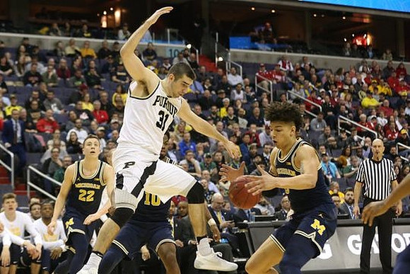 Duncan Robinson (22), Derrick Walton Jr. (10), and D.J. Wilson (5)
