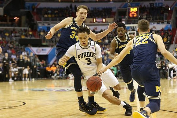 Mark Donnal (34), Derrick Walton Jr. (10), and Duncan Robinson (22)