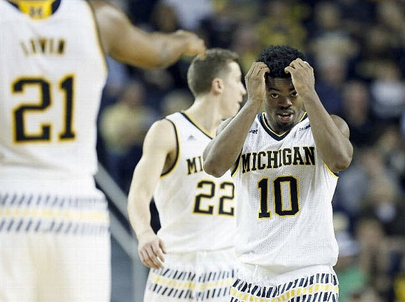 Zak Irvin (21), Duncan Robinson (22), and Derrick Walton Jr. (10)