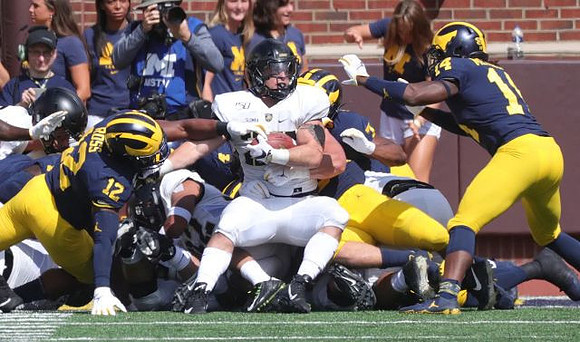 Josh Ross (12), Khaleke Hudson (7), and Josh Metellus (14)
