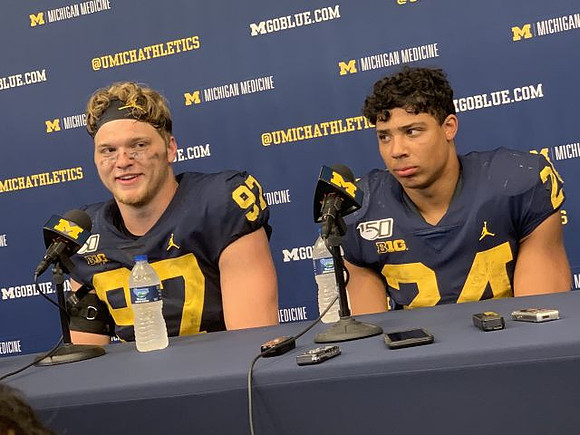 Aidan Hutchinson (97) and Zach Charbonnet (24)