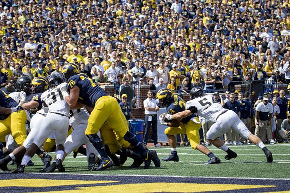 Sean McKeon (84), Ryan Hayes (76), and Zach Charbonnet (24)