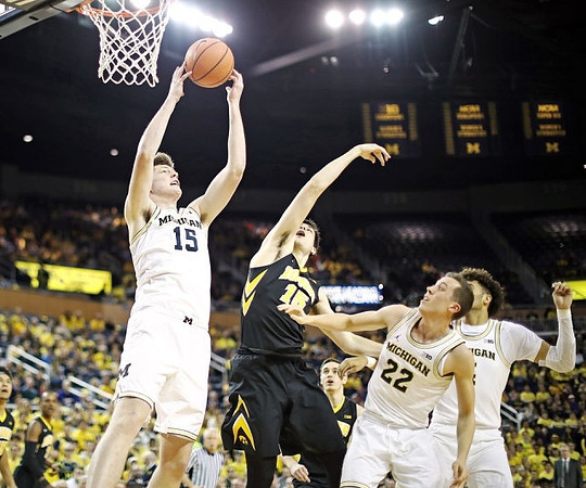 Jon Teske (15), Duncan Robinson (22), and Isaiah Livers (4)