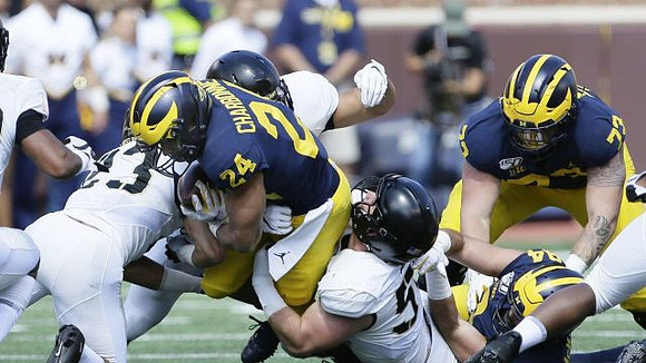 Zach Charbonnet (24), Sean McKeon (84), and Jalen Mayfield (73)