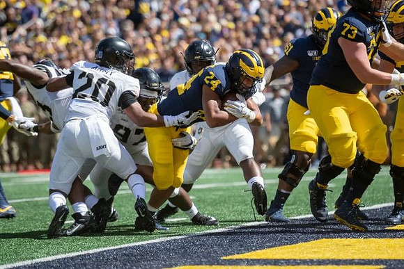 Zach Charbonnet (24), Cesar Ruiz (51), and Jalen Mayfield (73)
