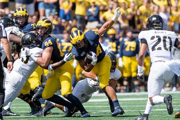 Jalen Mayfield (73), Sean McKeon (84), and Zach Charbonnet (24)