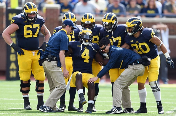 Kyle Kalis (67), De'Veon Smith (4), Drake Johnson (20), and Michigan Team
