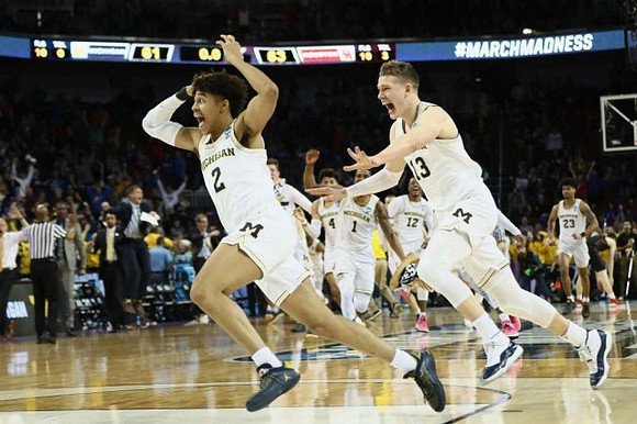 Jordan Poole (2), Moritz Wagner (13), and Michigan Team