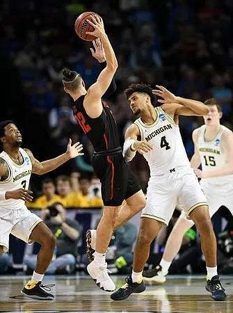 Zavier Simpson (3), Isaiah Livers (4), and Jon Teske (15)