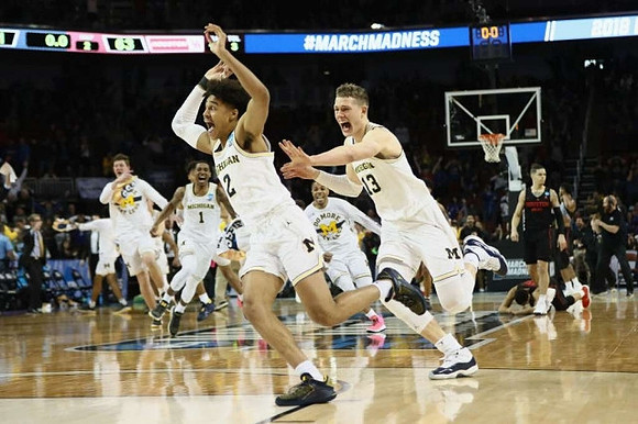 Jordan Poole (2), Moritz Wagner (13), and Michigan Team