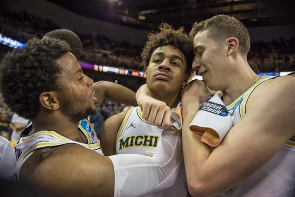 Jordan Poole (2), Zavier Simpson (3), and Duncan Robinson (22)