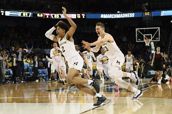 Jordan Poole (2), Moritz Wagner (13), and Michigan Team