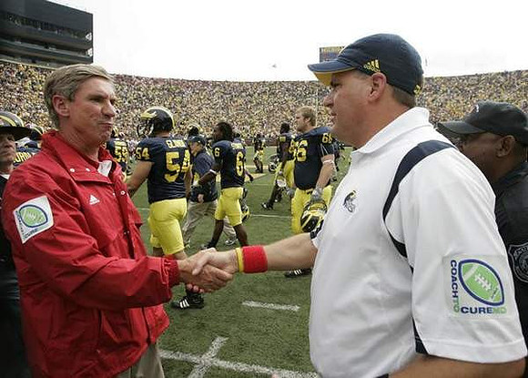Bill Lynch, Rich Rodriguez, Jareth Glanda (54), Je'Ron Stokes (6), and Christian Brandt (66)