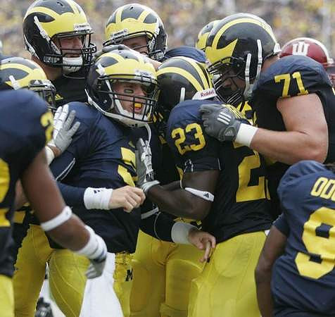 Tate Forcier (5), Carlos Brown (23), Mark Ortmann (71), and Martavious Odoms (9)