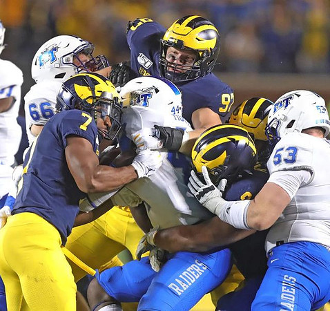 Khaleke Hudson (7), Aidan Hutchinson (97), and Carlo Kemp (2)