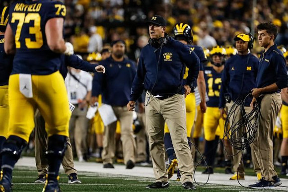 Jalen Mayfield (73) and Jim Harbaugh