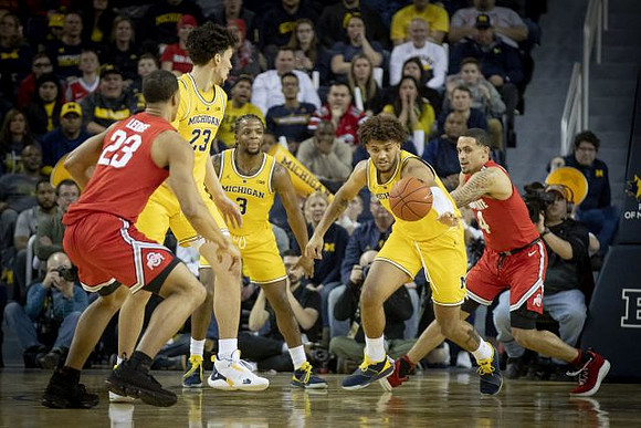 Brandon Johns Jr. (23), Zavier Simpson (3), and Isaiah Livers (4)