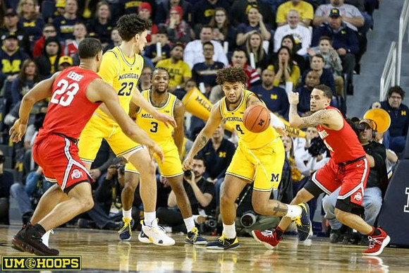 Brandon Johns Jr. (23), Zavier Simpson (3), and Isaiah Livers (4)