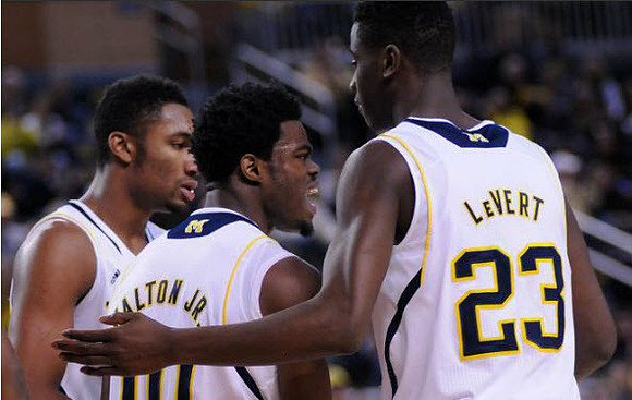 Zak Irvin (21), Derrick Walton Jr. (10), and Caris LeVert (23)