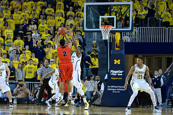 Derrick Walton Jr. (10), Caris LeVert (23), and Zak Irvin (21)