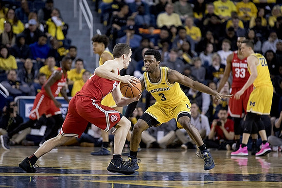 Jordan Poole (2), Zavier Simpson (3), and Duncan Robinson (22)