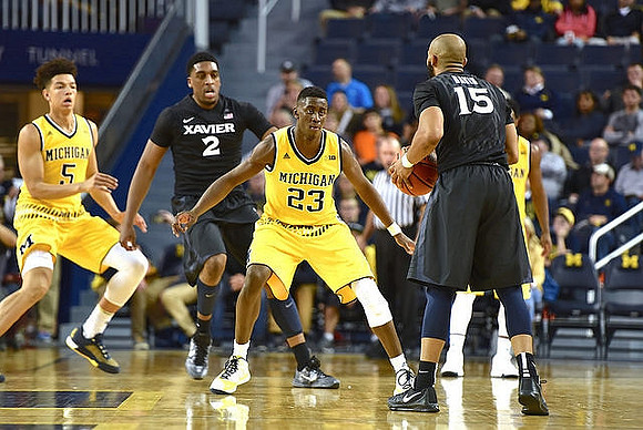D.J. Wilson (5) and Caris LeVert (23)