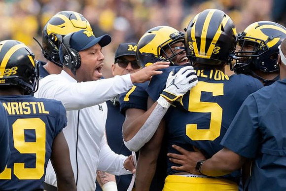 Mike Sainristil (19), Josh Gattis, Jim Harbaugh, Tarik Black (7), and Joe Milton (5)