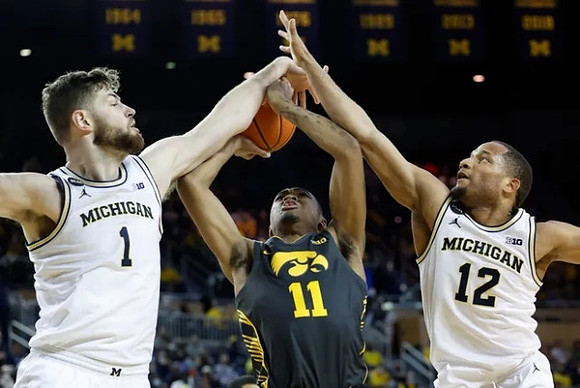 Hunter Dickinson (1) and DeVante' Jones (12)