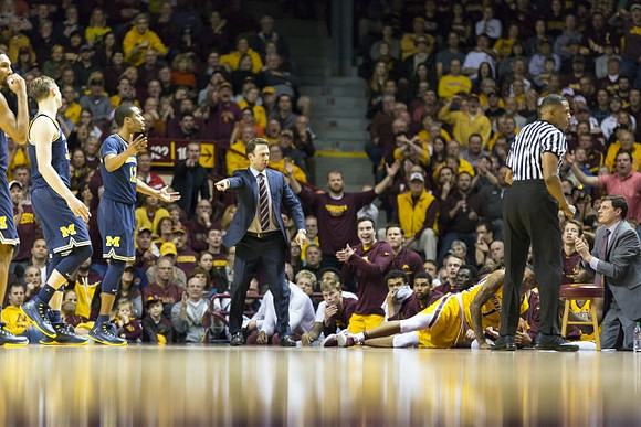 Zak Irvin (21), Mark Donnal (34), Muhammad-Ali Abdur-Rahkman (12), and Minnesota Head Coach Richard Pitino