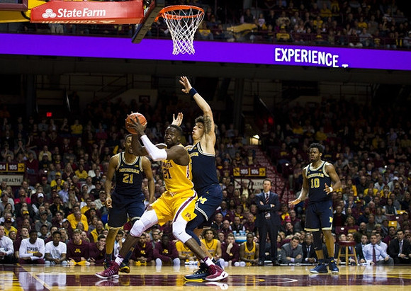 Zak Irvin (21), D.J. Wilson (5), Minnesota Head Coach Richard Pitino, and Derrick Walton Jr. (10)