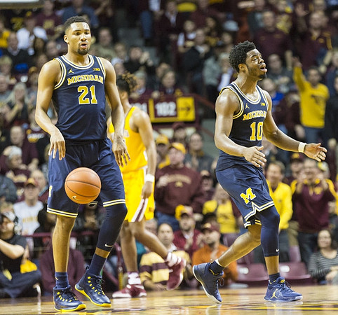 Zak Irvin (21) and Derrick Walton Jr. (10)