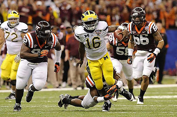 Mark Huyge (72) and Denard Robinson (16)