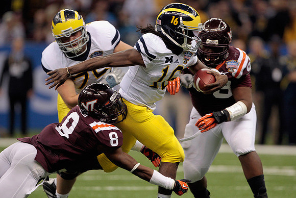 Mark Huyge (72) and Denard Robinson (16)