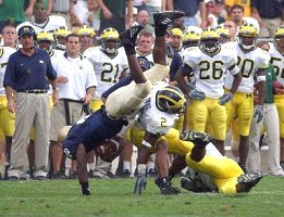Cato June (2), Lloyd Carr, Jeremy LeSueur (21), and Julius Curry (26)
