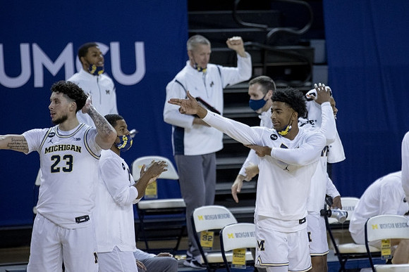 Brandon Johns Jr. (23), Jace Howard (25), and Michigan Team