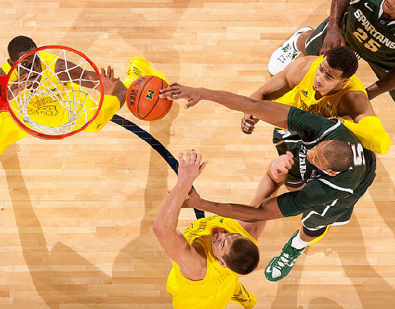 Caris LeVert (23), Mitch McGary (4), and Jordan Morgan (52)