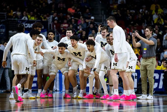 Zavier Simpson (3), Jon Teske (15), and Michigan Team
