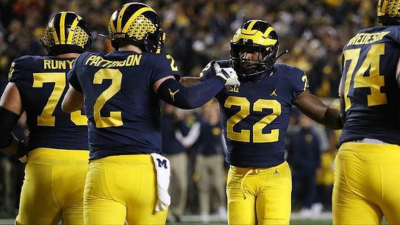 Jon Runyan Jr. (75), Shea Patterson (2), Karan Higdon (22), and Ben Bredeson (74)