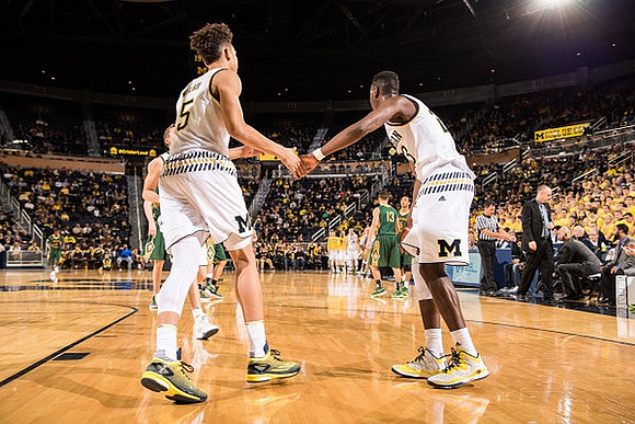 D.J. Wilson (5) and Caris LeVert (23)