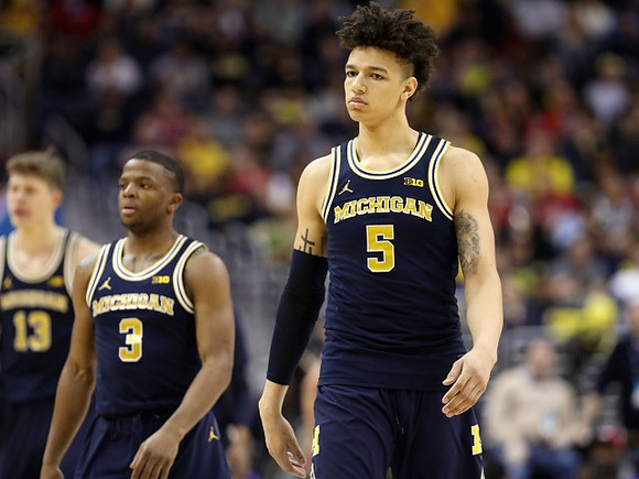 Moritz Wagner (13), Xavier Simpson (3), and D.J. Wilson (5)