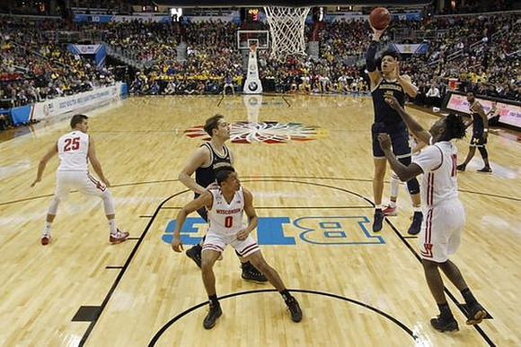 Mark Donnal (34), D.J. Wilson (5), and Derrick Walton Jr. (10)