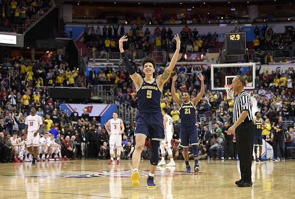 D.J. Wilson (5) and Zak Irvin (21)