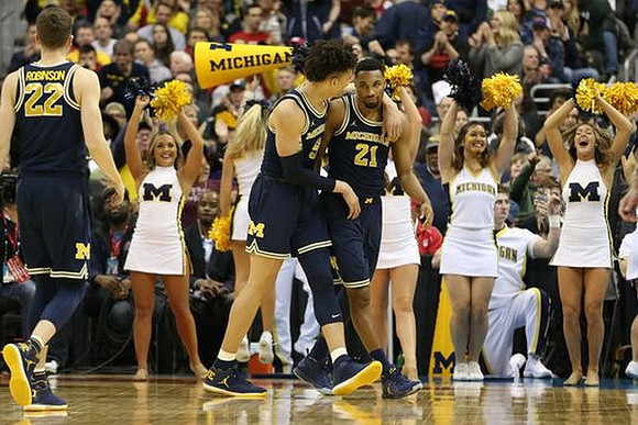 Duncan Robinson (22), D.J. Wilson (5), and Zak Irvin (21)