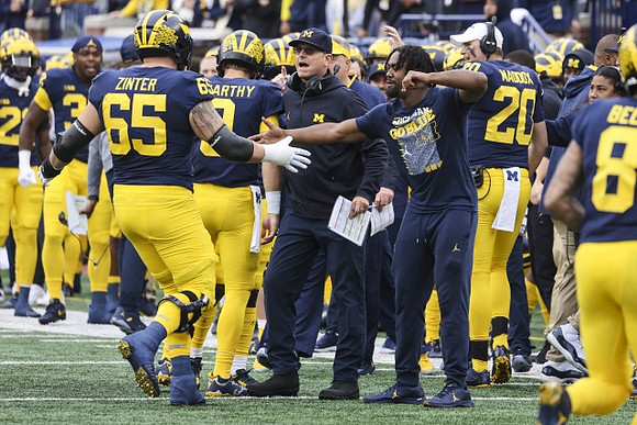 Zak Zinter (65), J.J. McCarthy (9), Jim Harbaugh, Donovan Edwards (7), Andy Maddox (20), and Ronnie Bell (8)